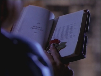 C holds a book open to Sonnet XXIX, with a pressed rose marking the page